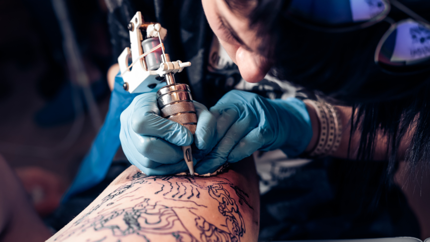 En tatuerare kan spendera upp till flera timmar sittandes i en obekväm arbetsställning vilket påverkar kroppen negativt. Foto: Shutterstock